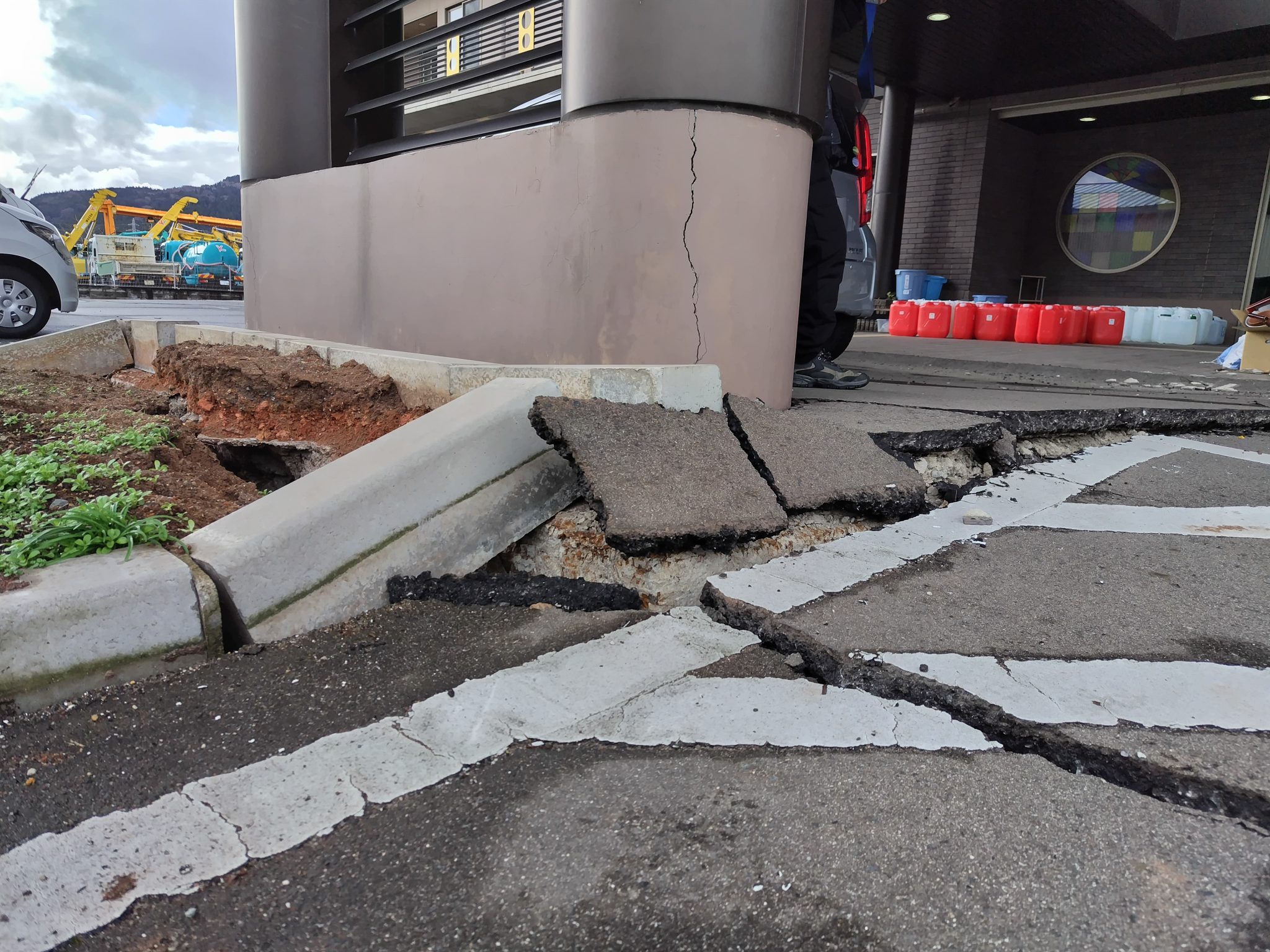 建物の柱はひび割れ、地面は隆起